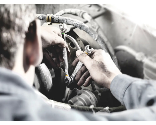 Mechanik s kľúčmi pri oprave motora