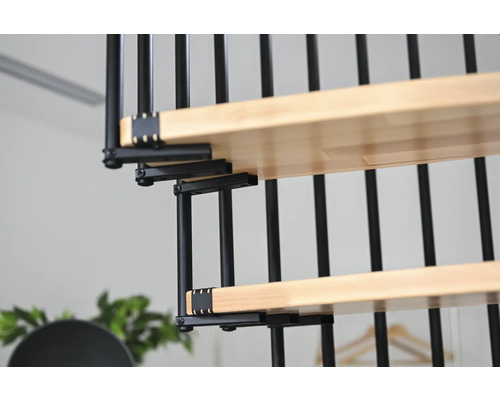 Detailný pohľad na točité schodisko s drevenými stupňami a čiernym kovovým zábradlím