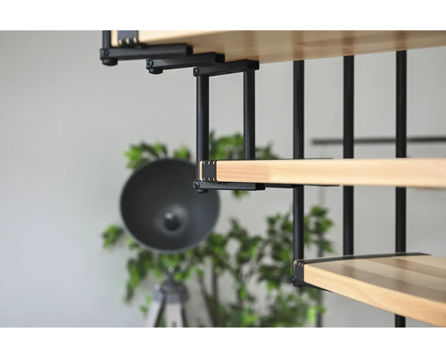 Detailný pohľad na drevené schodisko s čiernym kovovým zábradlím