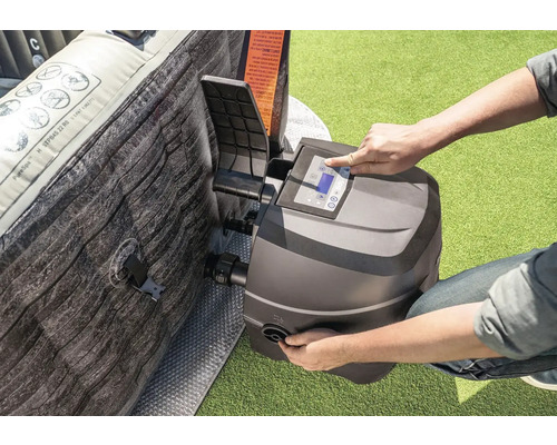 Osoba obsluhuje ovládací panel vírivky vedľa nafukovacej vírivky.