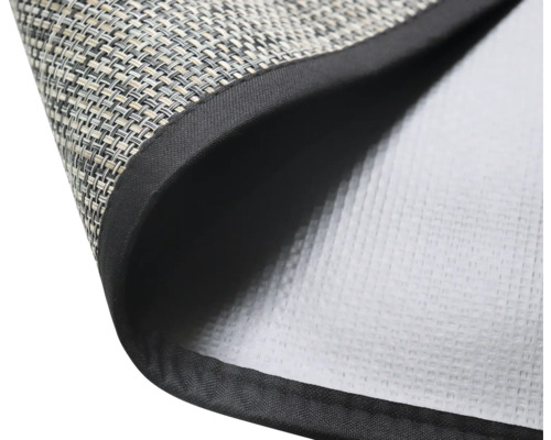 Detailný záber prestierania s tkaným povrchom a čiernym okrajom