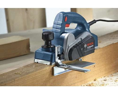 Elektrický hoblík pri hobľovaní drevenej dosky.