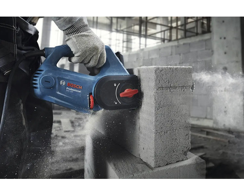 Ruka v rukavici reže pórobetónovú tvárnicu drážkovacou pílou.