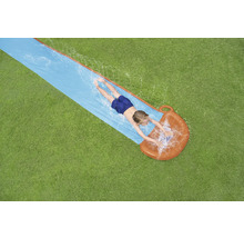 Pohľad zhora na dieťa ležiace na vodnej šmýkačke v záhrade