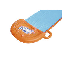 Striekajúca voda na nafukovacej vodnej šmýkačke v záhrade