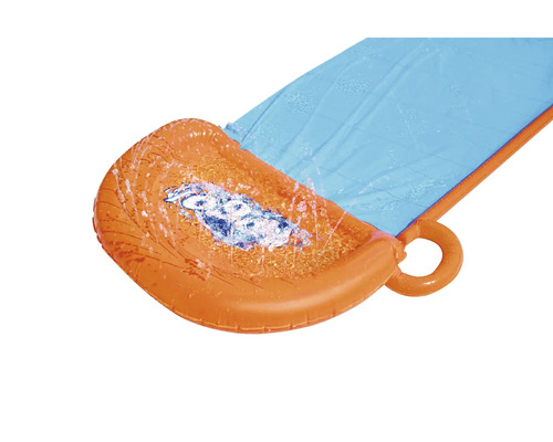 Striekajúca voda na nafukovacej vodnej šmýkačke v záhrade