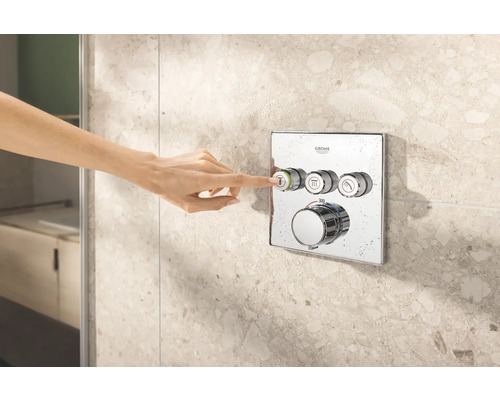 Ruka ovláda sprchovú armatúru Grohe na obkladanej stene