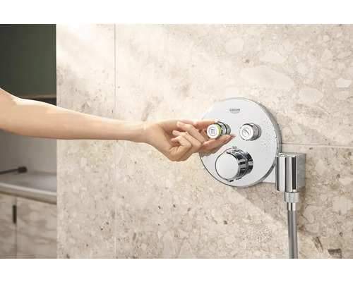 Ženská ruka ovláda sprchovú armatúru Grohe v kúpeľni