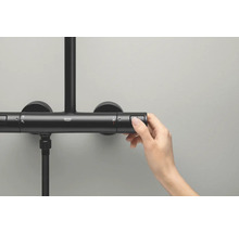 Detailný záber ruky ovládajúcej termostatickú sprchovú batériu Grohe