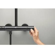 Fotografia ruky ovládajúcej sprchový termostat Grohe