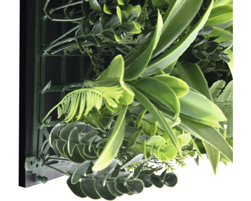 Detailný záber umelej rastlinnej steny s rôznymi odtieňmi zelenej