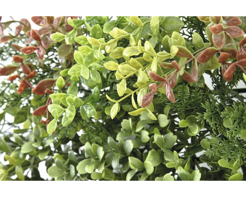 Detailný záber umelých rastlín so zelenými a hnedými listami