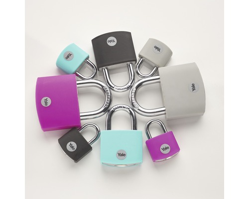 Niekoľko farebných visiacich zámkov značky Yale usporiadaných do kruhu na rovnom povrchu.