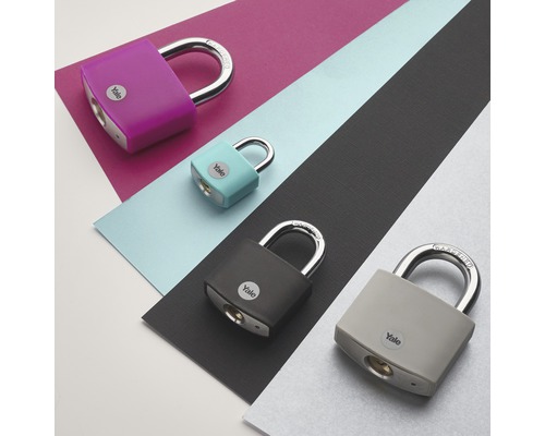 Viacfarebné visiace zámky značky Yale na farebnom pozadí
