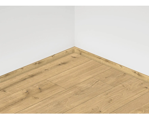 Položená laminátová podlaha s ladiacou podlahovou lištou pri bielej stene