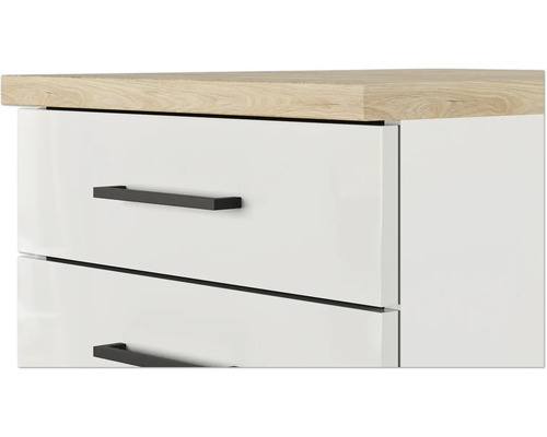 Detail bieleho zásuvkového modulu s drevenou doskou a čiernymi úchytmi