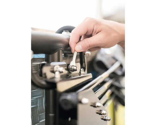 Osoba upevňuje kovový diel kľúčom.