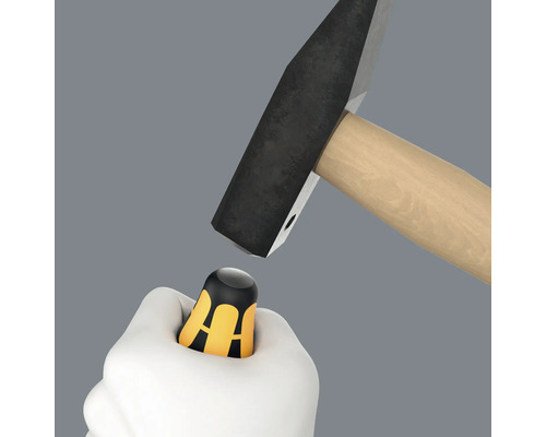 Kladivo dopadá na rukoväť skrutkovača v ruke