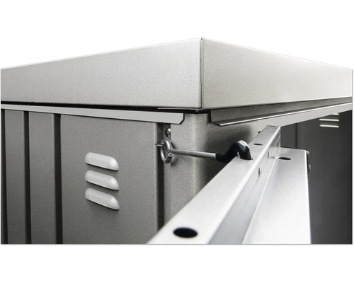 Detailný pohľad na záhradný domček s kovovými prvkami, vetracími otvormi a uzamykacím mechanizmom.