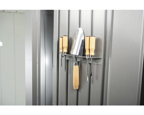 Záhradné náradie a skrutkovače namontované na kovovej stene