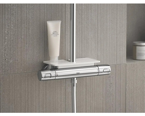 Sprchová armatúra s poličkou a produktom pre starostlivosť o telo v kúpeľni