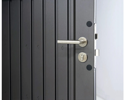 Detail sivých vchodových dverí so striebornou kľučkou a kľúčovou dierkou