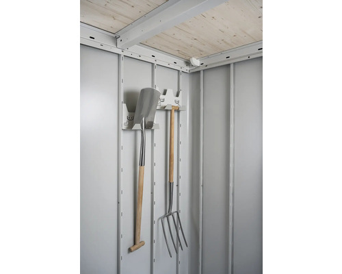Interiér záhradného domčeka so záhradným náradím, ako je rýľ a vidly na hnoj, na držiaku