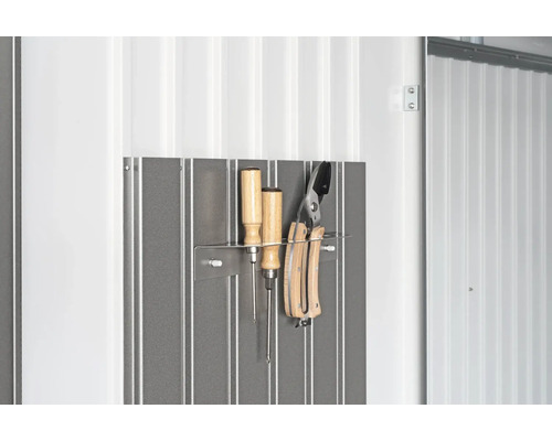 Uloženie náradia na kovovej stene so skrutkovačmi a záhradníckymi nožnicami