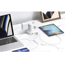Rozbočka s USB portami a pripojenými elektronickými zariadeniami na stole