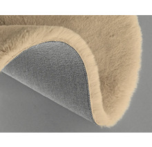 Detail béžového koberca s chlpatým povrchom a textilnou spodnou stranou