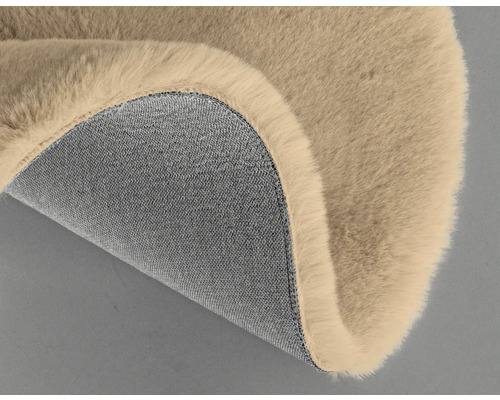 Detail béžového koberca s chlpatým povrchom a textilnou spodnou stranou