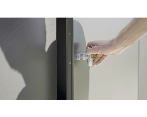 Ruka otvára skriňu na náradie s kľučkou a zámkom.