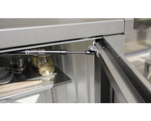 Detailný pohľad na plynový tlmič na záhradnej skrini