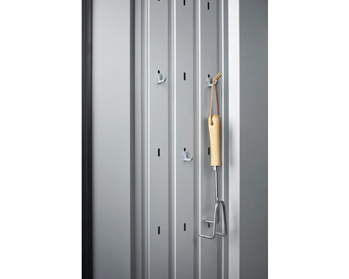 Kovová stena s háčikmi a záhradný kultivátor