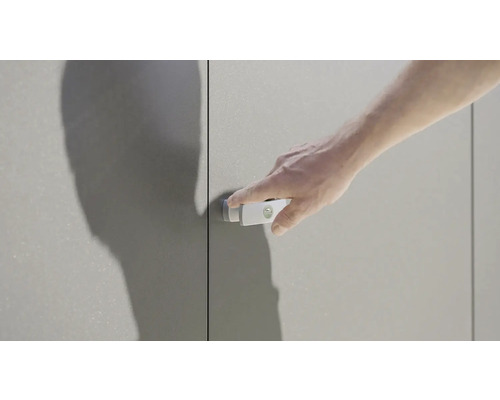 Muž otvára skriňu s jednoduchou rukoväťou.