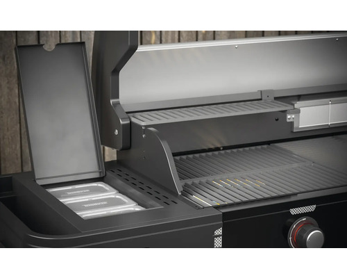 Detailný pohľad na čierny plynový gril s ohrievacím roštom a nádobami