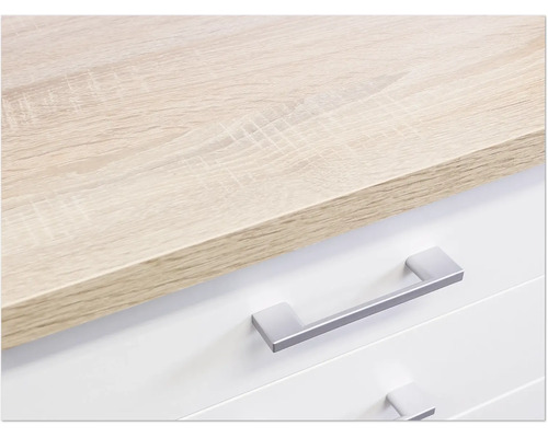 Detail komody so svetlohnedou drevenou doskou a striebornými úchytkami