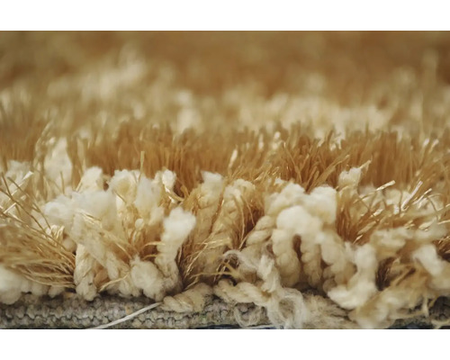 Detail béžového koberca s vysokým vlasom