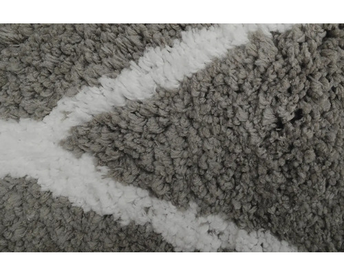 Detailný pohľad na sivo-biely koberec s geometrickým vzorom