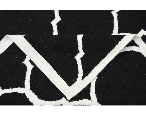 Detail čierneho koberca s bielym geometrickým vzorom