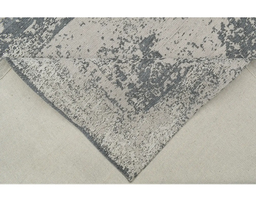 Sivý koberec s abstraktným vzorom.