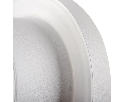 Detail okrúhleho bieleho stropného svietidla.