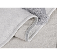 Detailný záber svetlej textilnej kúpeľňovej predložky