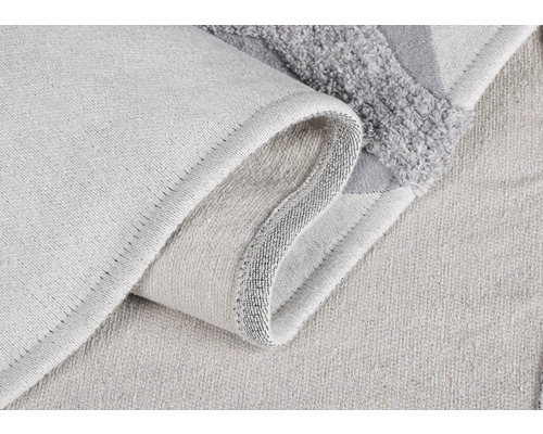 Detailný záber svetlej textilnej kúpeľňovej predložky