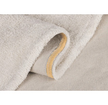 Detailný pohľad na svetlý kúpeľňový koberček s mäkkým povrchom