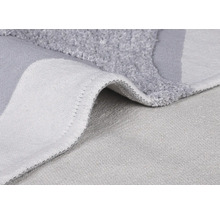 Detail šedej kúpeľňovej predložky s vlasom a tkanou zadnou stranou.