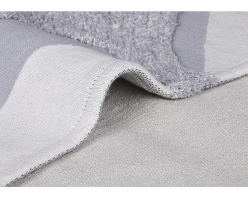 Detail šedej kúpeľňovej predložky s vlasom a tkanou zadnou stranou.