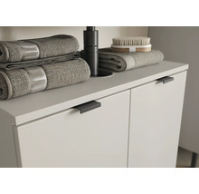 Skrinka pod umývadlo s uterákmi a kefou v kúpeľni