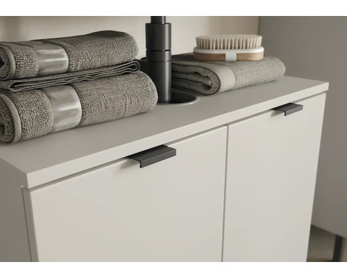 Skrinka pod umývadlo s uterákmi a kefou v kúpeľni