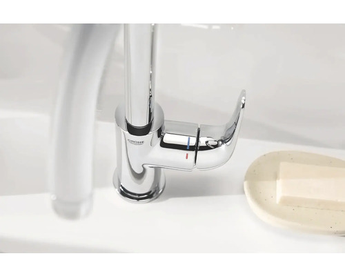 Logo spoločnosti Grohe. Jednopáková batéria z kovu na umývadle.